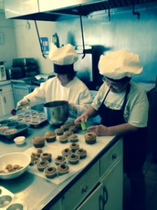 Ann Marie working alongside cook and job coach Shirley, baking Goldie's Gourmet Goodies.